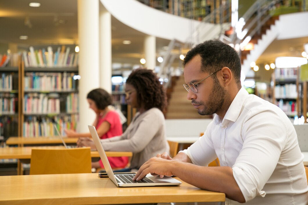 Estudantes usando computadores em uma biblioteca universitária